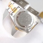 Navigator series men's watch with bright black dial, gold bezel, 42mm case, and two-tone Oyster bracelet.