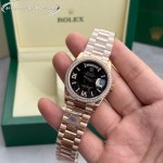 Sunday date display series women's watch with hematite-colored dial, diamond-set bezel, 36mm rose gold President-style bracelet.