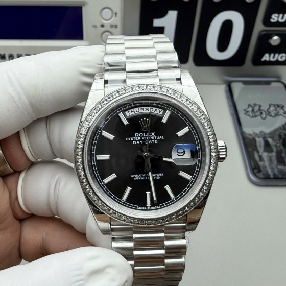 Sunday calendar series men's watch, black dial, diamond-set bezel, 40mm, silver President-style bracelet.