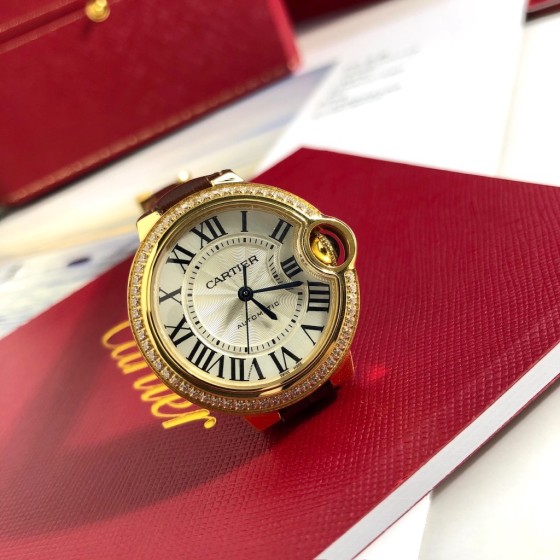Cartier Ballon Bleu series, 33mm women's watch with silver dial and diamond-set bezel, brown leather strap, mechanical movement.