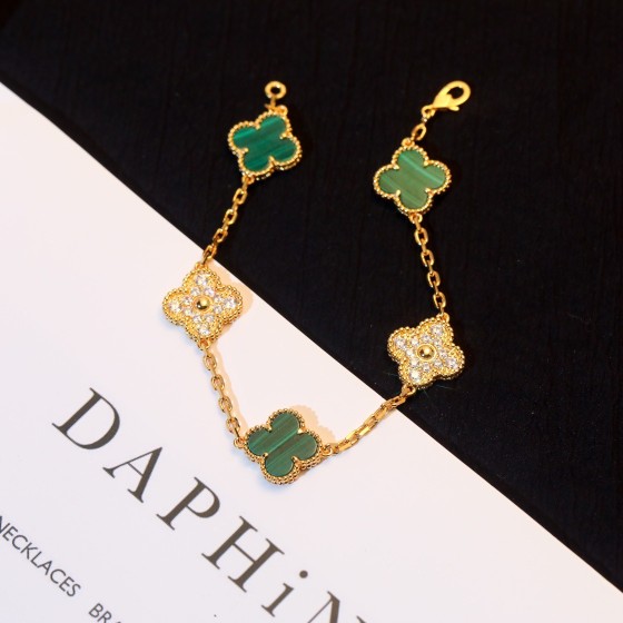 Four-leaf clover and peacock green enamel bracelet with interspersed rhinestones.