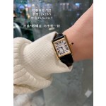 Cartier Tank watch, gold bezel, black leather strap.