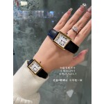Cartier Tank watch, gold bezel, black leather strap.